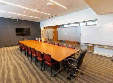 conference table with chairs and TV on wall